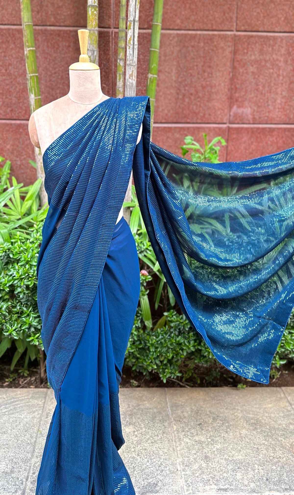 A mannequin draped in a stunning blue sequin saree embellished with blue sequin works