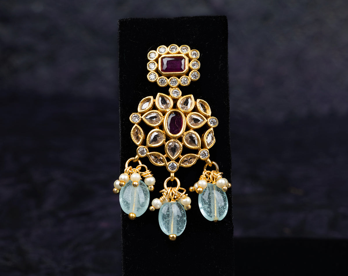 A fancy choker set with earrings desiged with blue beads and white kundan stones