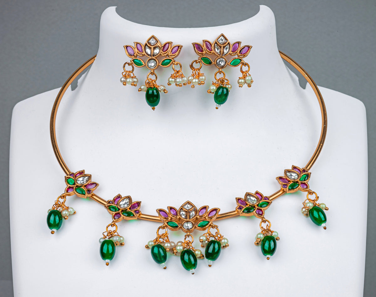 A gold pipe choker necklace with lotus design, pink stone and green beads, earrings in lotus design