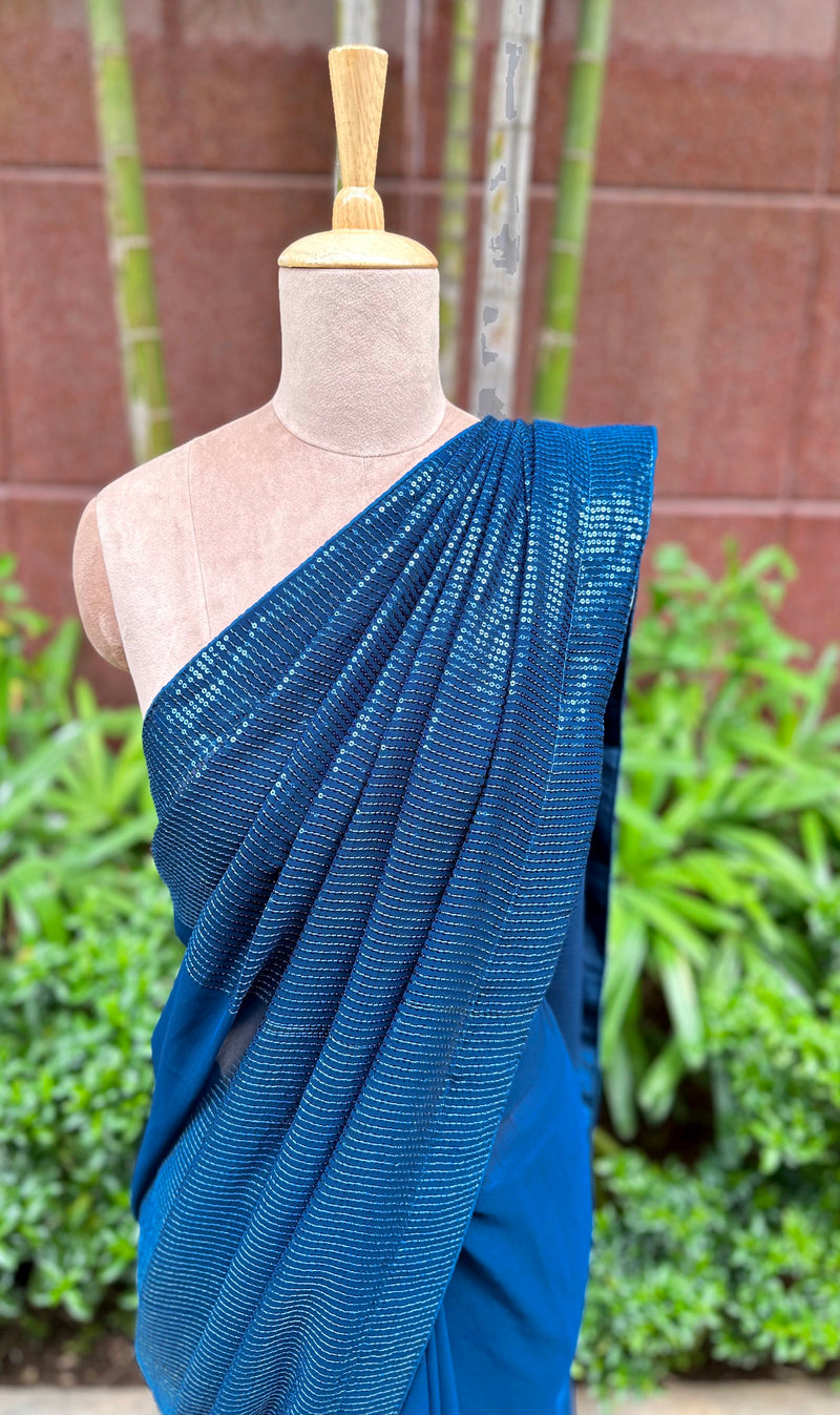 A mannequin draped in a stunning blue sequin saree embellished with blue sequin works