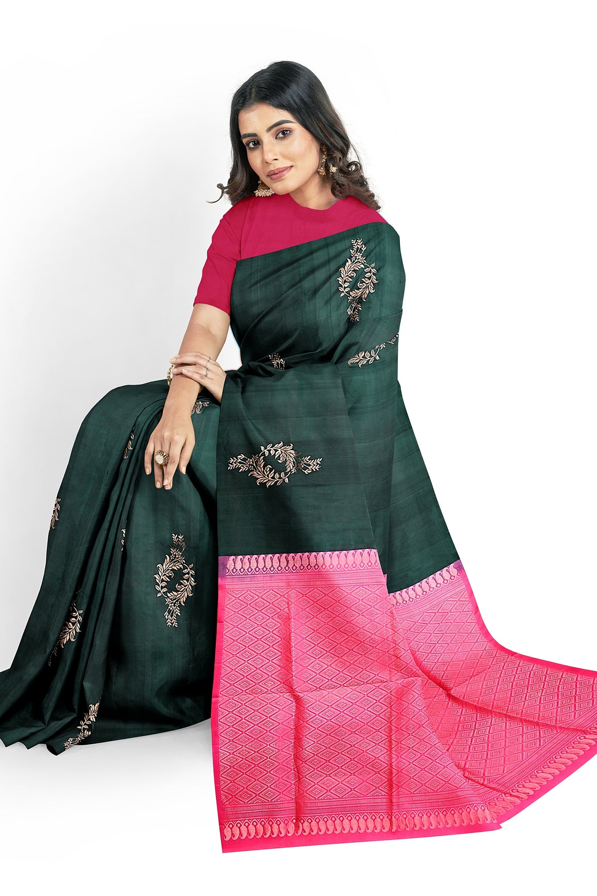 A model wearing a unique jungle green soft silk handloom saree with dark green body and rubine pink pallu. The saree is designed with floral motifs in gold zari works. The saree comes with a separate blouse material.