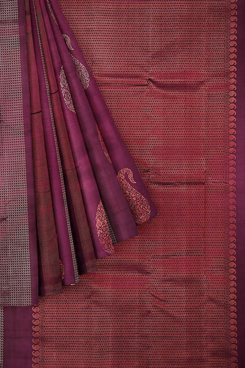 Kanchivaram handloom saree with the body & pallu in maroon with mango & geometrical motifs in silver & copper zari.
